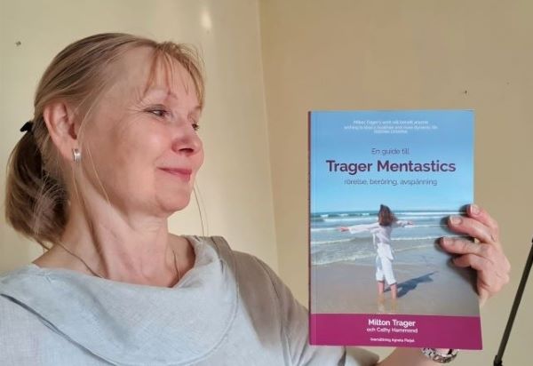 Birgitta Hultqvist visar upp boken "En guide till Trager Mentastics - rörelse, beröring, avspänning". 